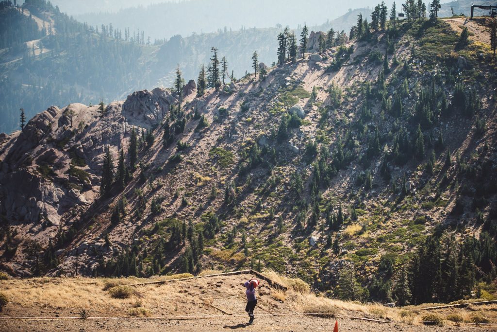 a racer carrying a giant barrel up Palisades Tahoe in the Spartan Ultra Race
