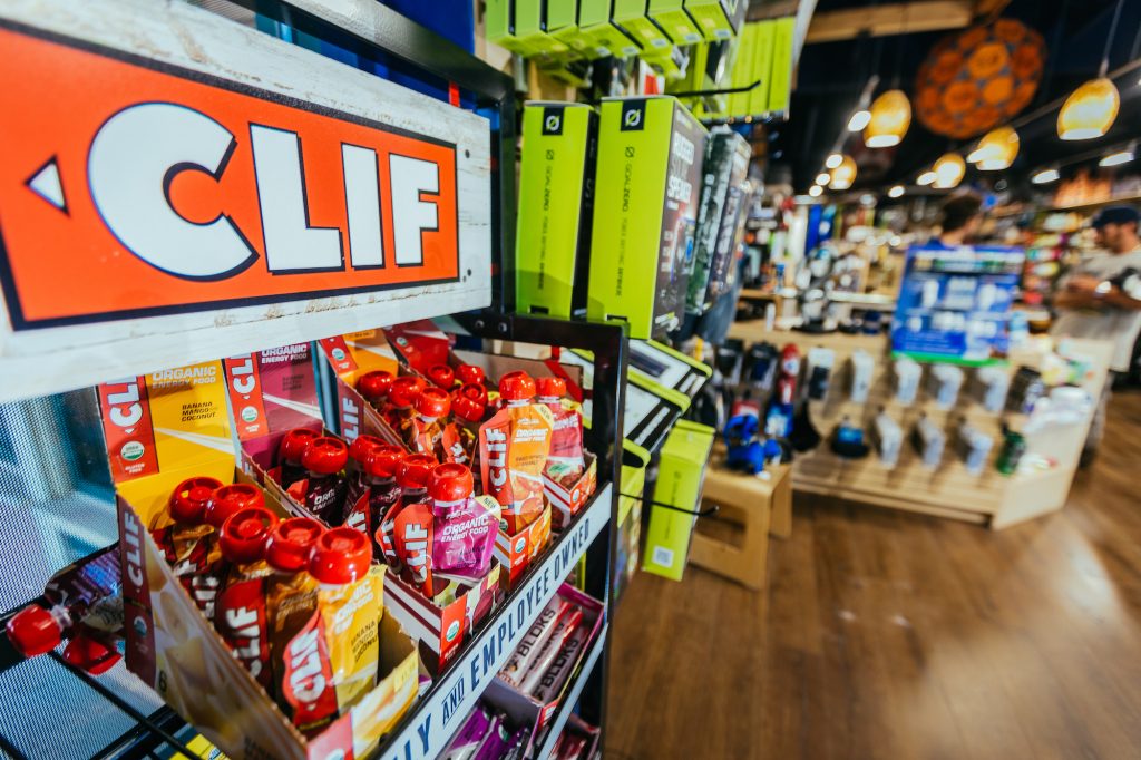 interior of Tahoe Mountain Sports with clif bar gels for sale and a customer buying items in the background