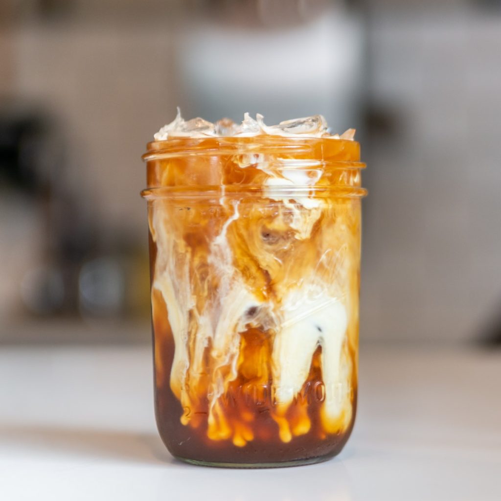 milk and coffee with ice cubes mixing inside of a mason jar at Fable Coffee in Grass Valley California