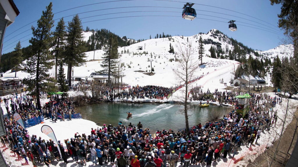 Cushing Crossing skier skiing across the pond with crowd in foreground at the Spring Skiing Capital