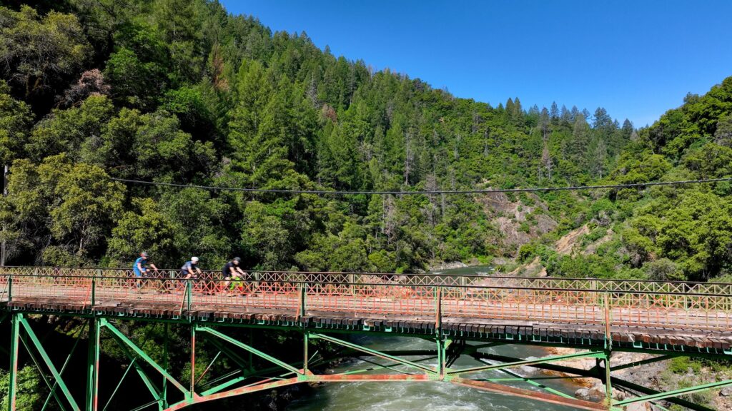 cyclists pedaling over South Yuba River on Heart Of Gold Gravel race