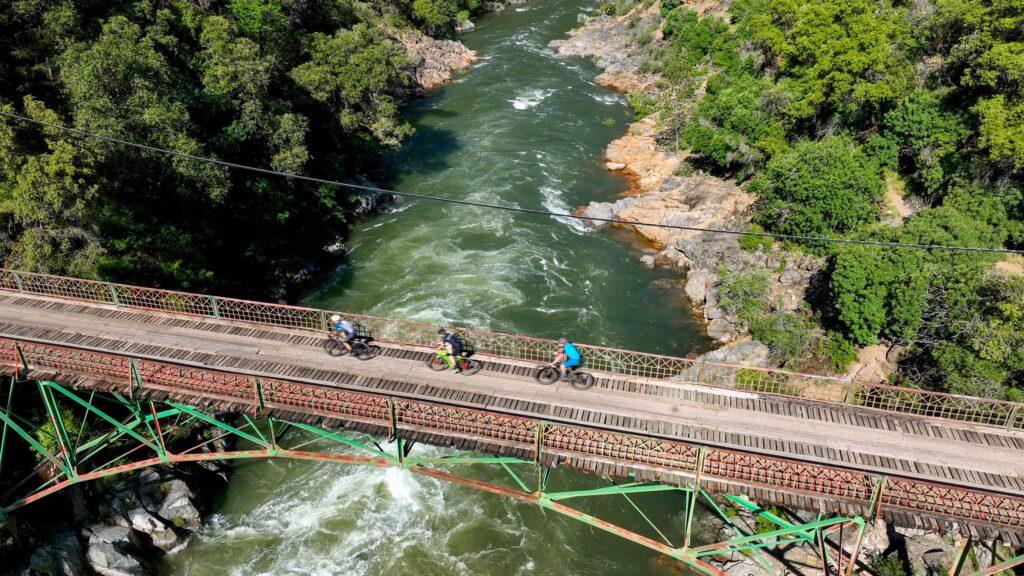 cyclists pedaling over South Yuba River on Heart Of Gold Gravel race from up above