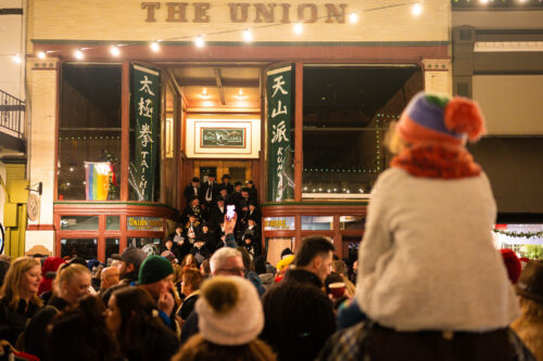 Kid taking in Carolers at Cornish Christmas