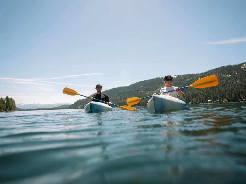 two kayakers paddling on Donner Lake in the summer