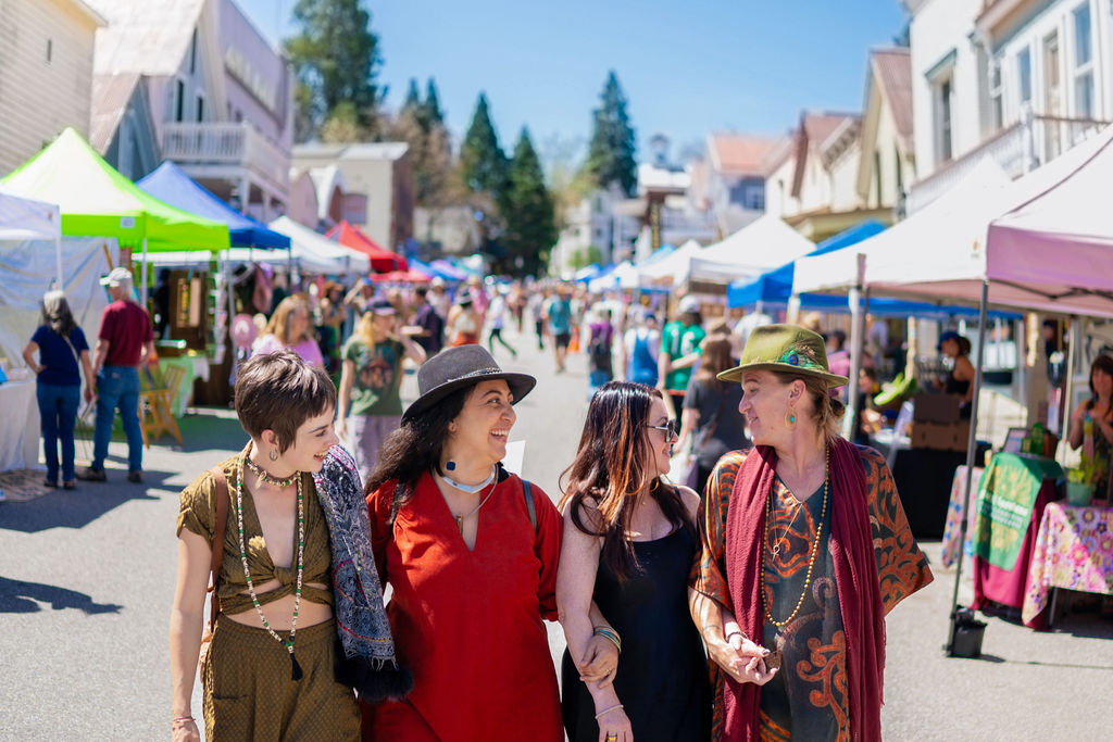 Four women smiling and enjoying Earth Fest at Nevada City California