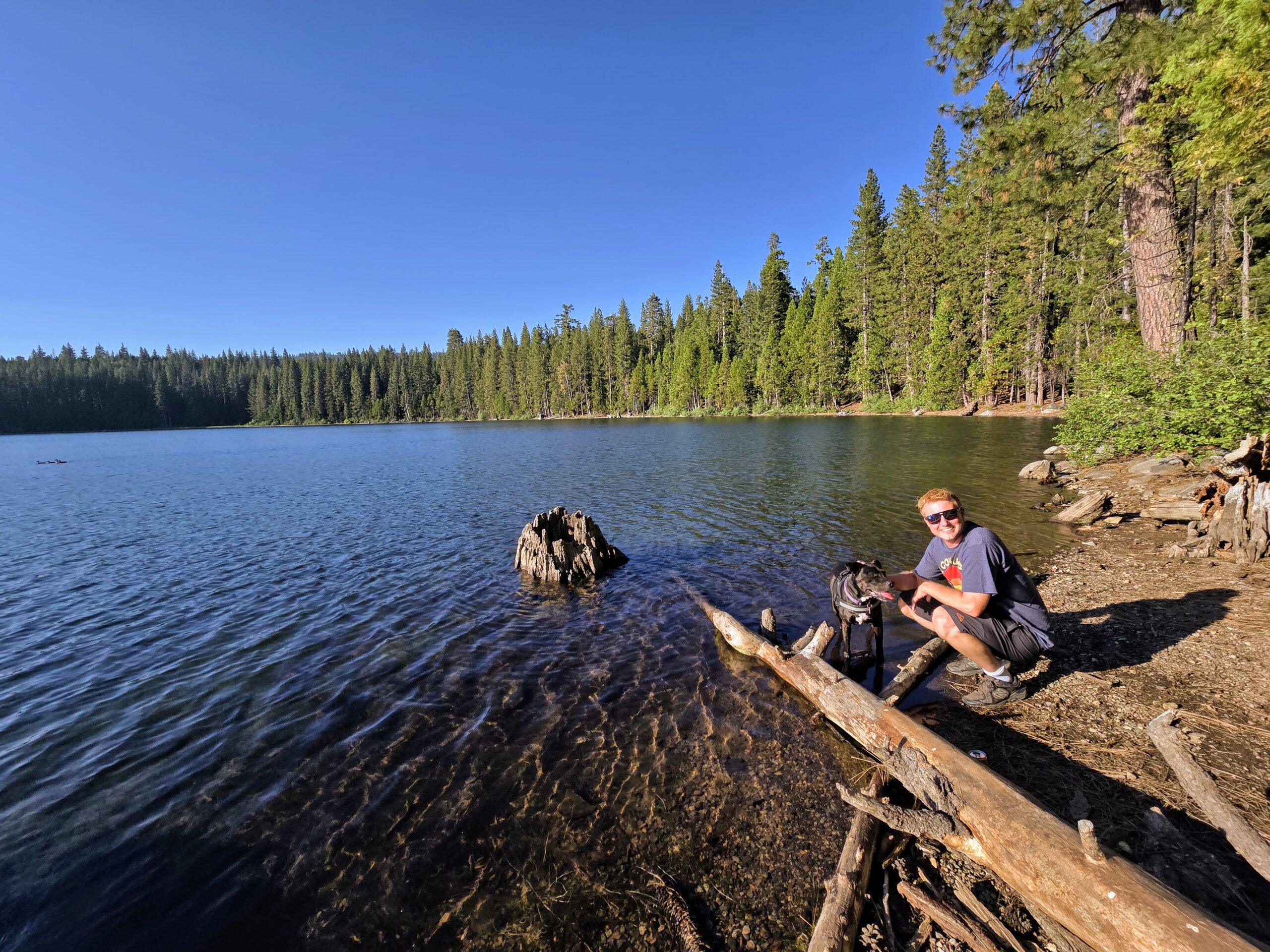 a calm sunset on Fuller Lake California in the Yuba Gap region of Nevada County with a dog and his partner